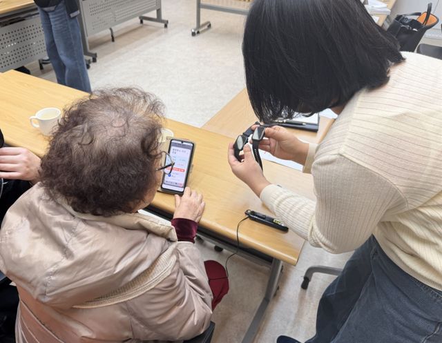광명시 직원이 ‘치매예방 스마트 건강케어사업'에 참여한 어르신에게 스마트워치 사용법을 설명해주고 있다. 광명시 제공