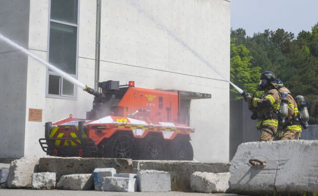 7일 오전 용인특례시 처인구 경기소방학교에서 열린 '무인소방로봇 명명식 및 시연식'에서 무인소방로봇 ‘파이로’가 소방대원과 함께 중장거리 방수를 시연하고 있다. 홍기웅기자
