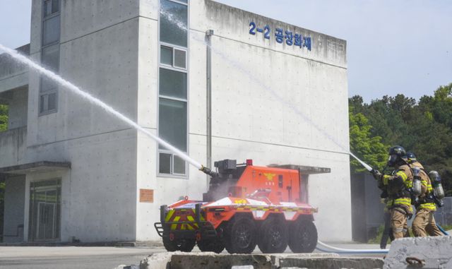 7일 오전 용인특례시 처인구 경기소방학교에서 열린 '무인소방로봇 명명식 및 시연식'에서 무인소방로봇 ‘파이로’가 소방대원과 함께 중장거리 방수를 시연하고 있다. 홍기웅기자