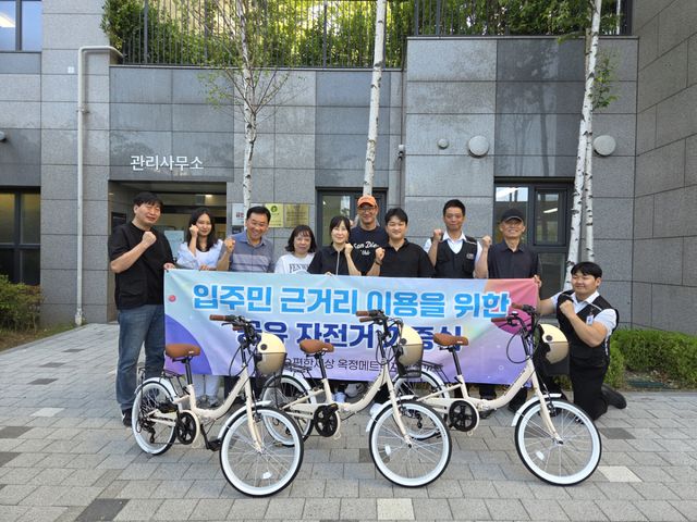 아파트 관리사무소 직원, 동대표, 보안업체 직원 등이 공유자전거 기증식에서 포즈를 취하고 있다. 옥정 메트로포레 입주자대표회의 제공
