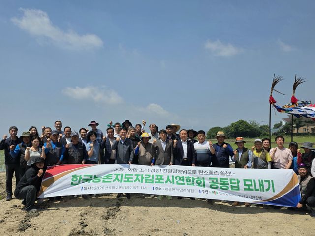 한국농촌지도자 김포시연합회가 주최한 공동운영답 모내기 행사에 참여한 인사들이 풍년을 기원하며 화이팅을 외치고 있다. 김포시 제공