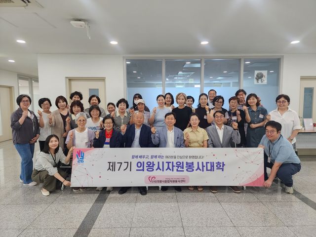 최동현 의왕시종합자원봉사센터 이사장과 안종서 센터장이 자원봉사대학 입학식에서 교육생들과 기념촬영을 하고 있다. 의왕시종합자원봉사센터 제공