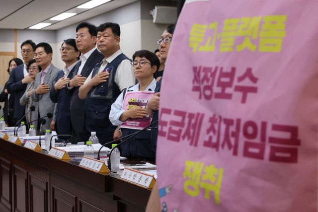 11일 정부세종청사 최저임금위원회에서 열린 제5차 전원회의에서 근로자위원과 사용자위원들이 국기에 경례하는 모습. 연합뉴스