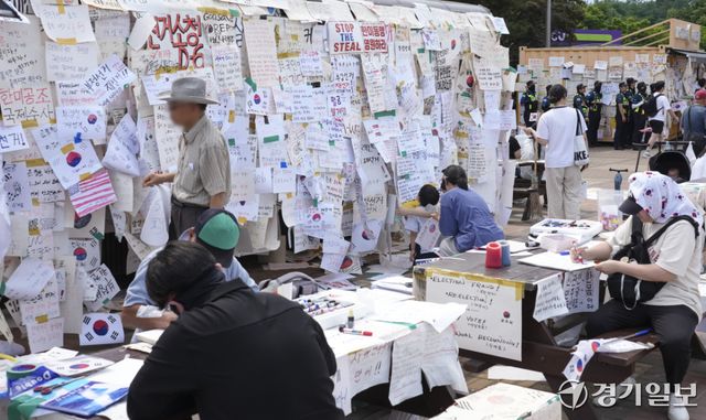 제9회 전국동시지방선거 투표용지 부족 사태에 반발한 시민들이 14일 서울시 송파구 올림픽공원 핸드볼경기장 일대에서 시민들이 도화지에 적은 응원 및 구호 등을 작성하고 있다. 홍기웅기자