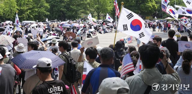 제9회 전국동시지방선거 투표용지 부족 사태에 반발한 시민들이 14일 서울시 송파구 올림픽공원 핸드볼경기장 일대에 모여 애국가를 부르거나, '부정선거, 재선거, 당일투표, 수개표' 요구하는 구호를 외치고 있다. 홍기웅기자