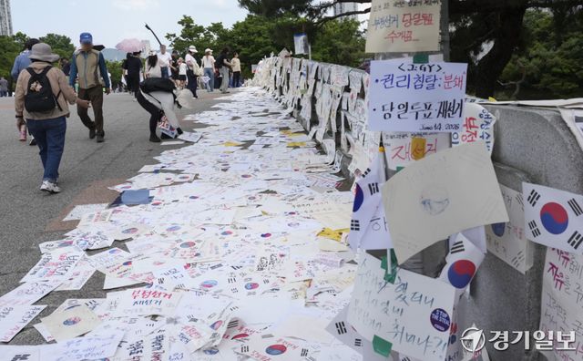 제9회 전국동시지방선거 투표용지 부족 사태에 반발한 시민들이 14일 서울시 송파구 올림픽공원 핸드볼경기장 일대에서 시민들이 도화지에 적은 구호 등을 다리 위에 게시하고 있다. 홍기웅기자