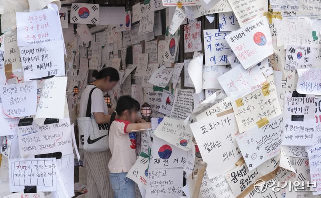 제9회 전국동시지방선거 투표용지 부족 사태에 반발한 시민들이 14일 서울시 송파구 올림픽공원 핸드볼경기장 일대에서 한 모녀가 태극기를 그리며 응원 등을 남기고 있다. 홍기웅기자