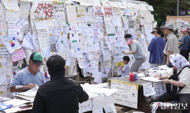 제9회 전국동시지방선거 투표용지 부족 사태에 반발한 시민들이 14일 서울시 송파구 올림픽공원 핸드볼경기장 일대에서 시민들이 도화지에 적은 응원 및 구호 등을 작성하고 있다. 홍기웅기자