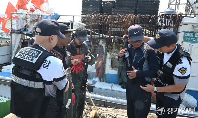 15일 오전 인천 중구 인천항 연안부두에서 인항파출소 해양경찰이 조업을 나가는 어선원들에게 구명조끼 착용 의무화를 안내하고 있다. 오늘 7월 1일부터 일부 어선에 한정됐던 구명조끼 착용 의무를 확대해 승선 인원수와 관계없이 모든 어선원이 외부에 노출된 갑판에서 작업하거나 이동할 때 반드시 구명조끼를 착용하도록 한다.조병석기자