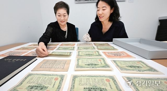 고 장래복씨의 자녀인 장성숙 ㈔중소기업융합경기연합회 고문이 지난해 인천광역시립박물관에 부친의 유산인 건국국채와 자서전을 기증하기에 앞서 박물관 관계자와 함께 살펴보고 있다. 경기일보DB