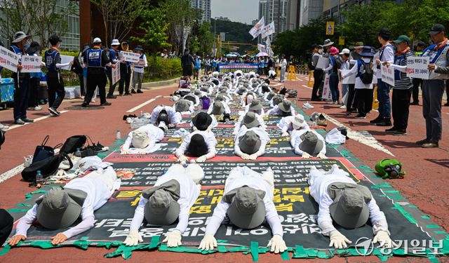 18일 오전 경기도청 2번 게이트 앞에서 전국장애인부모연대 경기지부 회원들이 발달 장애인에 대한 의료 및 재활 인프라에 대한 구축 등을 요구하며 오체투지를 하고 있다. 윤원규기자
