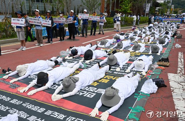 18일 오전 경기도청 2번 게이트 앞에서 전국장애인부모연대 경기지부 회원들이 발달 장애인에 대한 의료 및 재활 인프라에 대한 구축 등을 요구하며 오체투지를 하고 있다. 윤원규기자