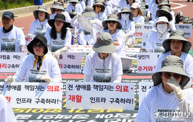 18일 오전 경기도청 2번 게이트 앞에서 전국장애인부모연대 경기지부 회원들이 발달 장애인에 대한 의료 및 재활 인프라에 대한 구축 등을 요구하고 있다. 윤원규기자
