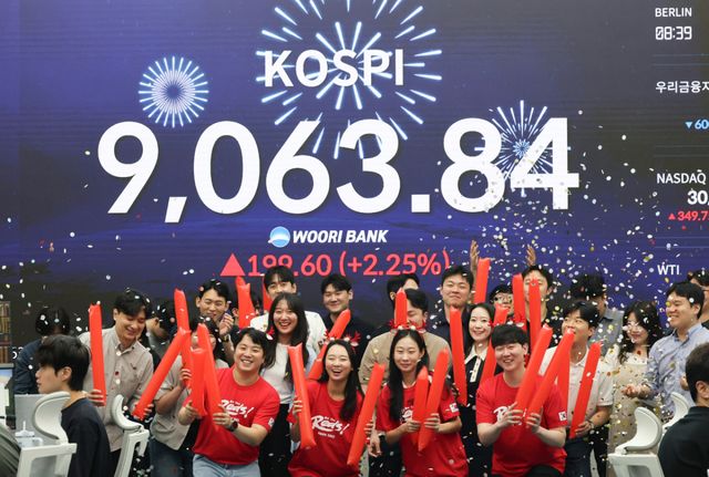 코스피가 사상 처음으로 종가 기준 9,000선을 돌파하며 장을 마친 18일 서울 중구 우리은행 본점 딜링룸에서 직원들이 축하 세리머니를 하고 있다. 연합뉴스