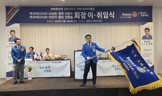 이천로타리클럽 제49대 안현철 회장이 취임식에서 클럽기를 이왕우 이임회장으로부터 이양받아 힘차게 흔들고 있다. 김정오기자