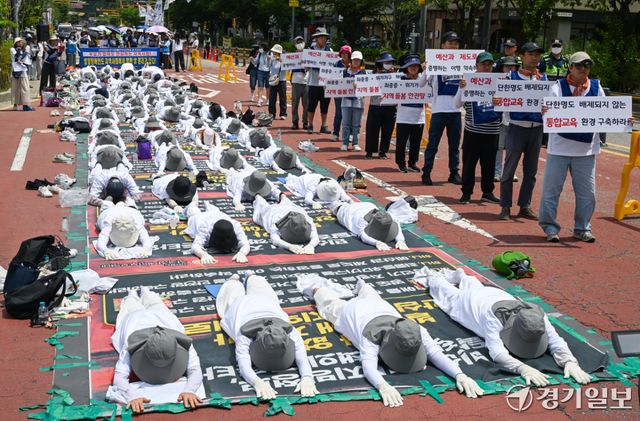 18일 오전 경기도청 2번 게이트 앞에서 전국장애인부모연대 경기지부 회원들이 발달 장애인에 대한 의료 및 재활 인프라에 대한 구축 등을 요구하며 오체투지를 하고 있다. 윤원규기자