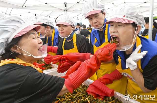 18일 오전 대한적십자사 경기도지사에서 열린 '하지엔 김장하지'에서 대한적십자가 봉사원이 일본적십자사 봉사원에게 양념을 버무린 열무김치를 먹여주고 있다. 이번 봉사활동은 60여명의 봉사원들이 김장한 열무김치 5kg을 지역 취약계층에 전달할 예정이다. 홍기웅기자