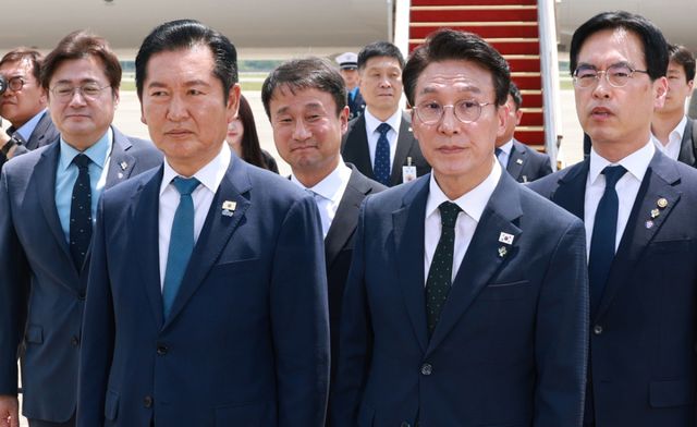 더불어민주당 정청래 대표와 김민석 총리가 18일 성남 서울공항에서 G7 정상회의와 유럽 순방을 마치고 귀국한 이재명 대통령과 인사를 나눈 뒤 의전 차량 이동을 기다리고 있다. 연합뉴스