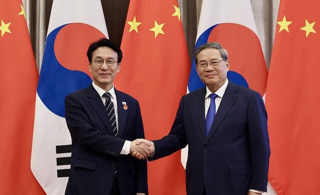 중국을 방문 중인 김민석 국무총리가 23일 중국 다롄의 방추도 호텔에서 리창 국무원 총리를 만나 회담에 앞서 악수하고 있다. 연합뉴스
