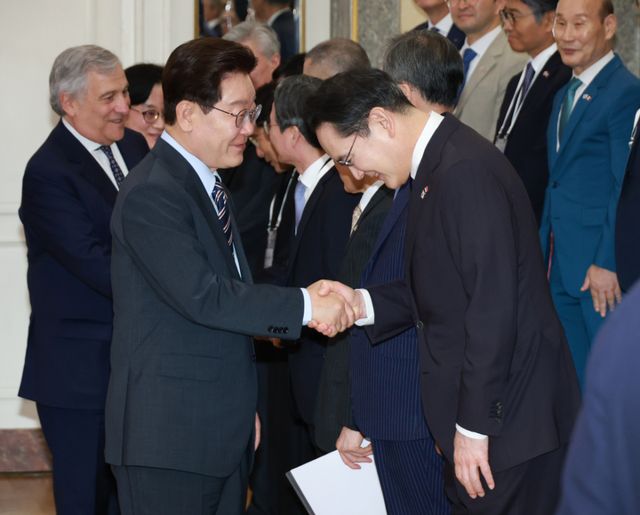 이재명 대통령이 12일(현지시간) 이탈리아 로마의 한 호텔에서 열린 비즈니스 라운드테이블에 입장하며 이재용 삼성전자 회장과 악수하고 있다. 연합뉴스