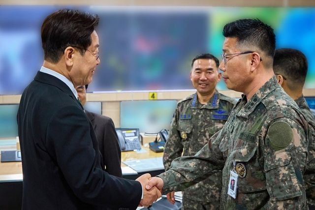 이재명 대통령이 3월27일 서울 용산 국방부에서 전군주요지휘관회의를 마친 뒤 지휘통제실을 찾아 조성현 대령을 격려하며 악수하고 있다. 청와대 제공