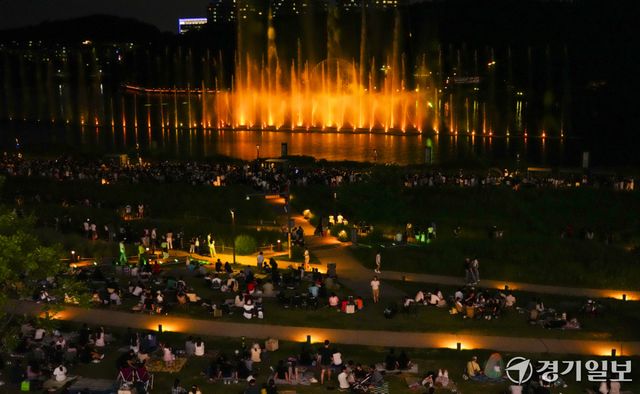 낮 기온이 30도를 웃도는 무더운 날씨가 이어지면서 해가 진 뒤 야외 활동에 나서는 시민들이 늘고 있다. 27일 저녁 화성특례시 동탄호수공원을 찾은 시민들이 화려한 동탄루나쇼를 관람하며 주말 여름밤을 즐기고 있다.