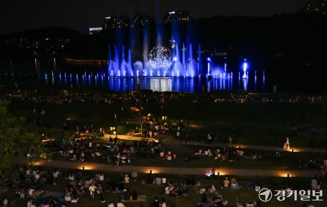 낮 기온이 30도를 웃도는 무더운 날씨가 이어지면서 해가 진 뒤 야외 활동에 나서는 시민들이 늘고 있다. 27일 저녁 화성특례시 동탄호수공원을 찾은 시민들이 화려한 동탄루나쇼를 관람하며 주말 여름밤을 즐기고 있다.