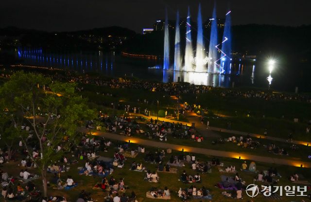 낮 기온이 30도를 웃도는 무더운 날씨가 이어지면서 해가 진 뒤 야외 활동에 나서는 시민들이 늘고 있다. 27일 저녁 화성특례시 동탄호수공원을 찾은 시민들이 화려한 동탄루나쇼를 관람하며 주말 여름밤을 즐기고 있다.