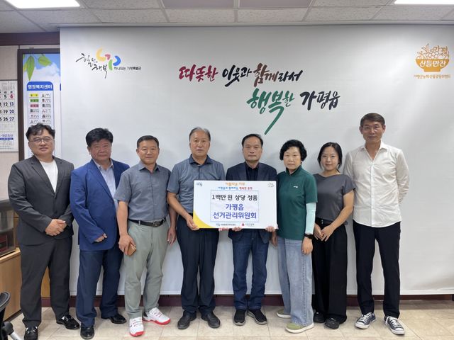 가평읍선거관리위원회가 최근 가평읍 행정복지센터를 방문해 100만원 상당의 이웃돕기 성품을 전달하고 기념촬영을 하고 있다. 가평군 제공