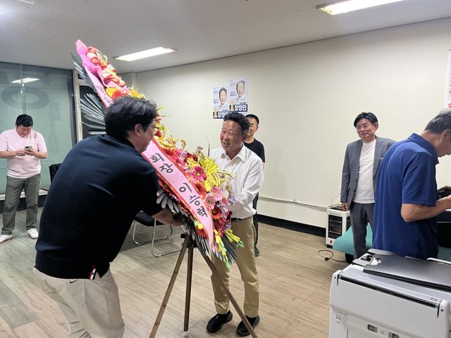 더불어민주당 장정민 옹진군수 후보가 당선 확정 직후 지지자들에게 대형 축하 화환을 건네 받고 있다. 이병기기자