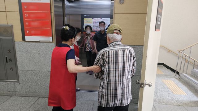 투표 사무원과 요양시설 관계자들이 3일 서구 가정1동 제2투표소에서 어르신을 부축해 안내하고 있다. 박기웅기자