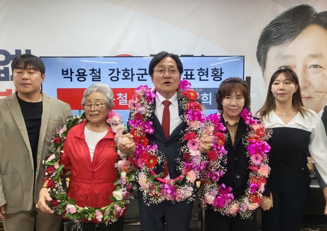 당선이 확실시되자 목에 꽃다발을 건 채 가족들의 손을 잡고 기뻐하는 국민의힘 박용철 강화군수 당선자. 조향래 기자
