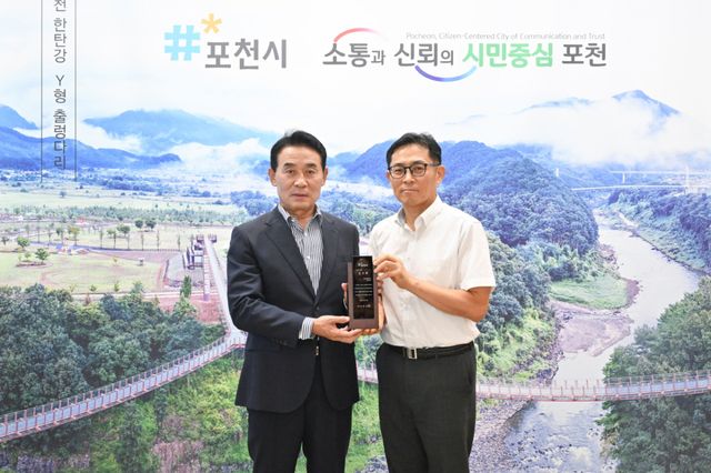 백영현 포천시장이 지난 29일 시장 집무실에서 소상공인 전기요금 특별지원사업 추진에 협력한 한국전력공사 포천지사에 감사패를 전달한 뒤 기념촬영을 하고 있다. 포천시 제공