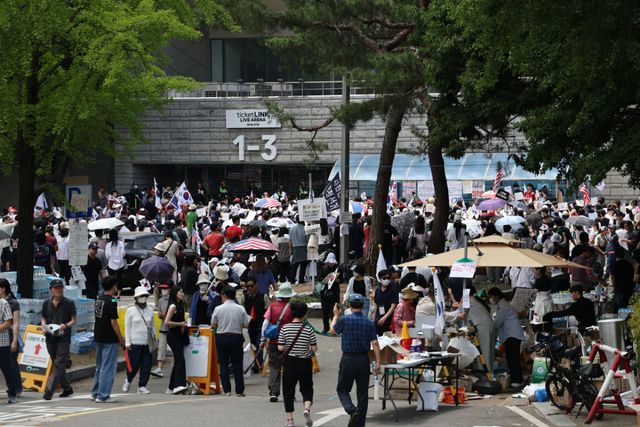 6·3 지방선거 투표용지 부족 사태를 규탄하며 재선거를 요구하는 '잠실 개표소 봉쇄 시위'가 계속되고 있는 8일 서울 송파구 올림픽공원 핸드볼경기장 출입구 앞에서 참가자들이 구호를 외치고 있다. 연합뉴스
