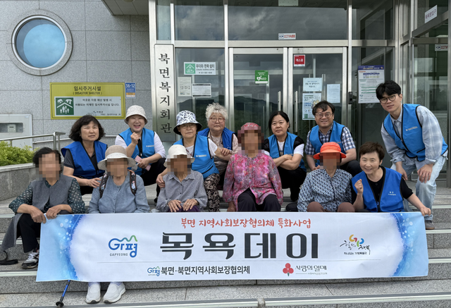 가평군 북면 지역사회보장협의체 위원들이 ‘목욕데이’ 사업에 참여한 홀몸 어르신들과 목욕을 마친 뒤 기념촬영을 하고 있다. 가평군 제공