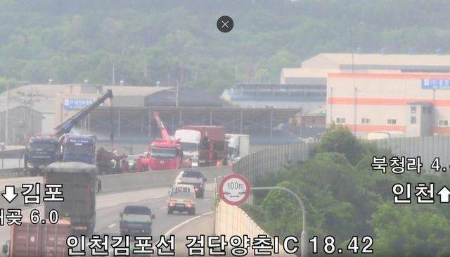 1일 오전 검단·양촌IC를 지나던 화물차에서 적재물이 떨어져 중장비가 이를 치우고 있다. 국가정보교통센터 폐쇄회로(CC)TV 갈무리