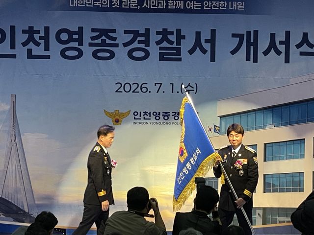 유동배 영종서장이(오른쪽) 한창훈 인천경찰청장(왼쪽)에게서 관서기를 전달받아 흔들고 있다. 이인엽 기자