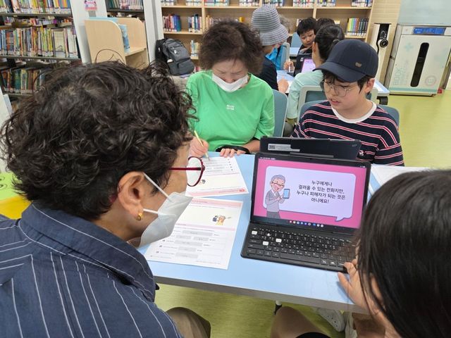 마송초등학교 학생들이 어르신들에게 노트북을 활용해 보이스피싱 예방 퀴즈를 설명하고 있다. 김포교육지원청 제공