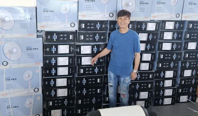 안상수 ㈔수와진의 사랑더하기 이사장이 선풍기 앞에서 기념촬영 하고 있다. 본인 제공