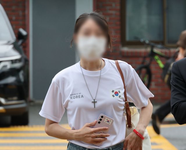 6·3 지방선거 개표소로 사용된 올림픽공원 핸드볼경기장 문 앞에서 체육단체 직원들의 장내 사무실 진입을 막아 업무 방해 혐의를 받는 30대 여성이 10일 서울 송파경찰서에서 조사받기 위해 출석하고 있다. 연합뉴스