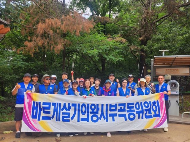 바르게살기운동 의왕시 부곡동위원회 김준기 회장과 회원, 부곡동주민센터 직원들이 여름철 집중호우와 장마에 대비해 덕성봉 일대에서 환경 정화와 안전 점검 활동을 한 뒤 기념촬영을 하고 있다. 의왕시 제공