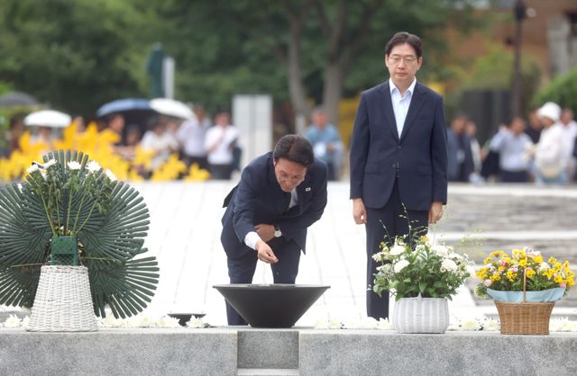 더불어민주당 당권주자인 김민석 전 국무총리가 17일 오후 경남 김해시 진영읍 봉하마을 노무현 전 대통령 묘역을 참배하며 분향하고 있다. 오른쪽은 김경수 전 경남지사. 연합뉴스