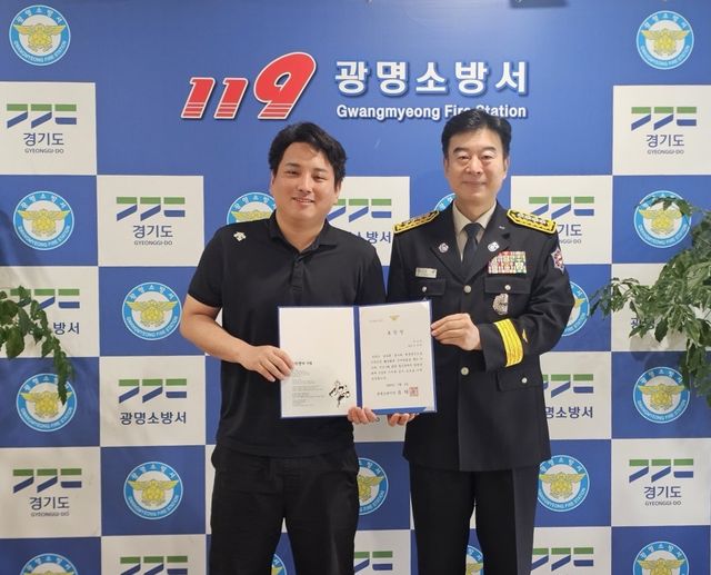 광명소방서가 김준희씨(왼쪽)에게 표창장을 수여하고 기념촬영을 하고 있다. 광명소방서 제공