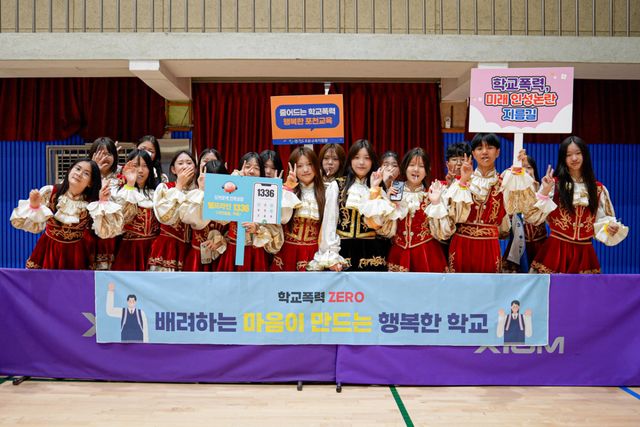 18일 포천고등학교 체육관에서 열린 ‘2026 공유학교와 함께하는 교육공동체 밴드 페스타’ 참가팀들이 공연을 마친 뒤 ‘줄어드는 학교폭력, 행복한 포천교육’ 등의 손팻말을 들고 학교폭력 예방 캠페인에 동참하며 기념촬영을 하고 있다. 포천교육지원청 제공