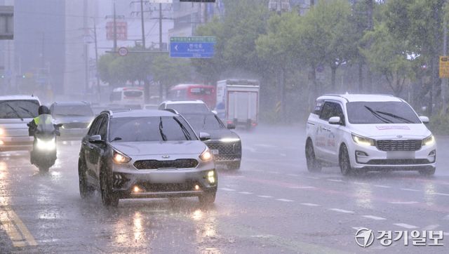 장마 영향으로 수도권 곳곳에 국지성 호우가 내리고 있는 6일 수원특례시 장안구 한 거리에서 갑작스러운 장대비에 차량들이 천천히 운행하고 있다. 홍기웅기자