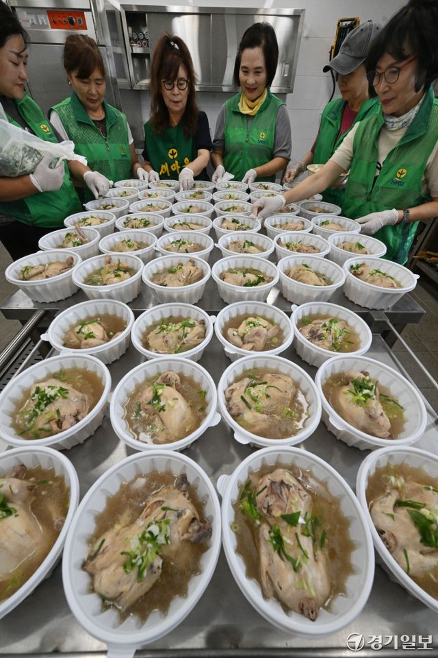 대서를 하루 앞둔 22일 오전 수원특례시 장안구 영화동행정복지센터에서 영화동 새마을부녀회 회원들이 관내 취약계층에게 전달할 삼계탕을 준비하고 있다. 김시범기자