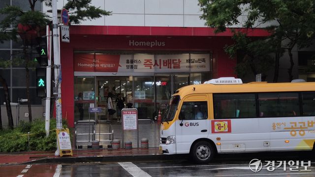 22일 홈플러스 영통점 입구에서 방문객들이 비를 피하는 모습. 금유진기자