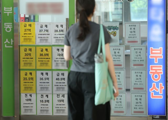 서울의 어느 부동산중개업소 앞에서 한 청년이 매물 전단를 보고 있다. 연합뉴스