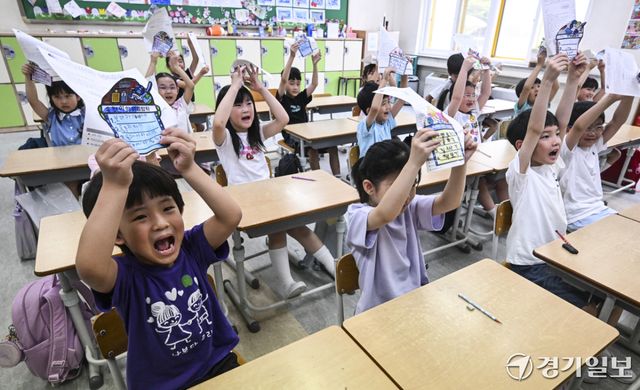 27일 오전 하계 방학식이 열린 수원특례시 효천초등학교에서 1학년 학생들이 환하게 웃으며 여름방학 통지문과 계획서를 들어보이고 있다. 홍기웅기자