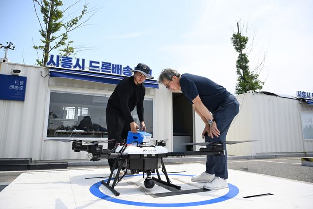 28일 오전 11시, 시흥시 배곧한울공원. 본보 김형수 기자가 주문한 피자를 관제센터 관계자가 드론에 싣고 있다. 시흥시 제공
